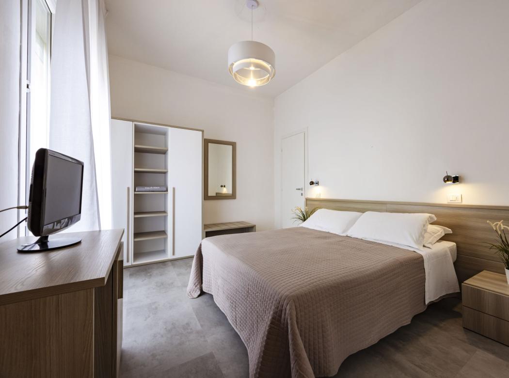 Bright, modern room with a cozy bed and elegant furnishings.