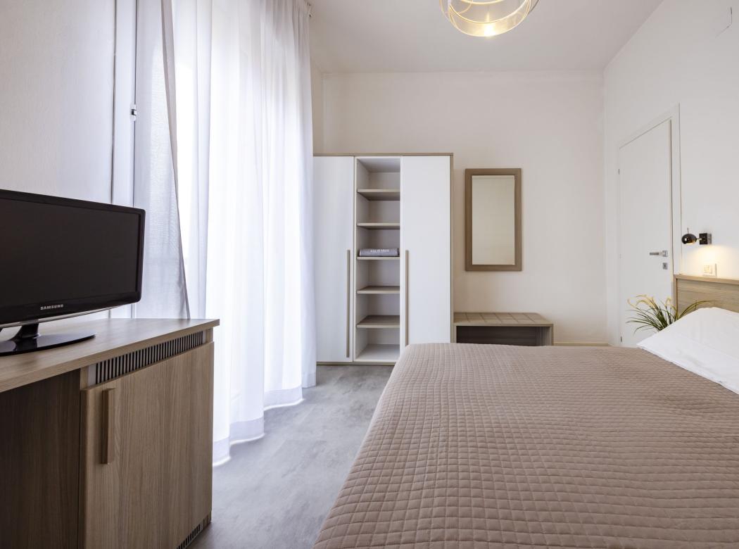 Bright room with cozy bed and modern furniture.