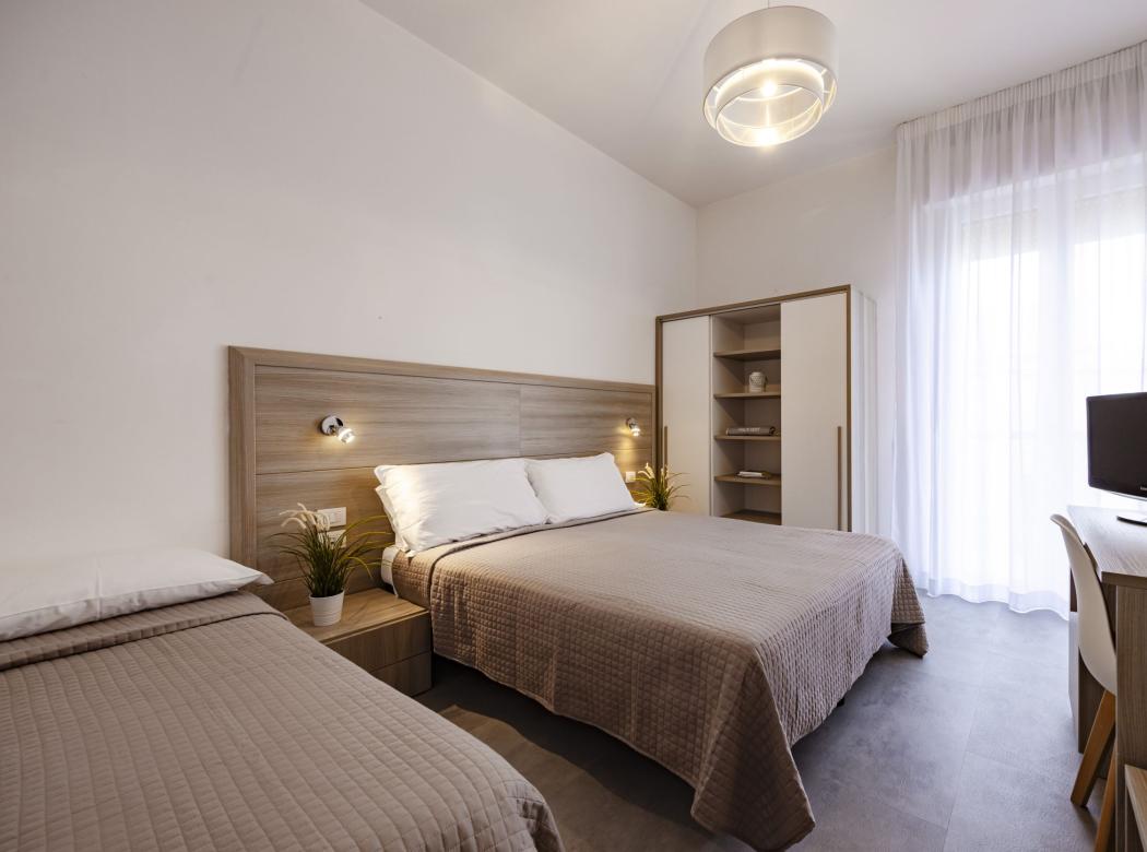Cozy room with tidy beds, soft lighting, and modern furnishings.