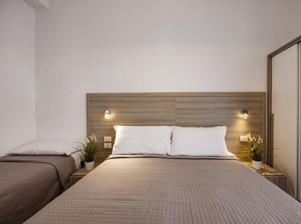 Cozy room with tidy beds, soft lighting, and decorative plants.
