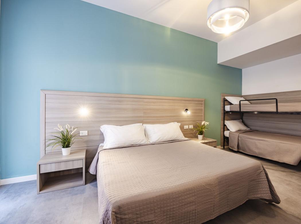 Cozy room with double bed and bunk beds, serene atmosphere.